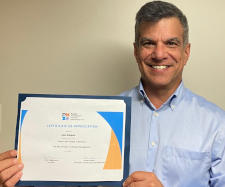 Picture of Isaac Rodriguez holding PMIW Certificate of Appreciation